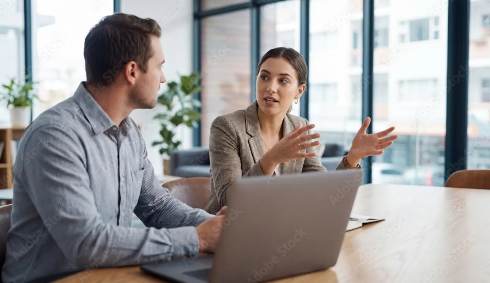 Zwei Personen besprechen einen Ablauf am Laptop