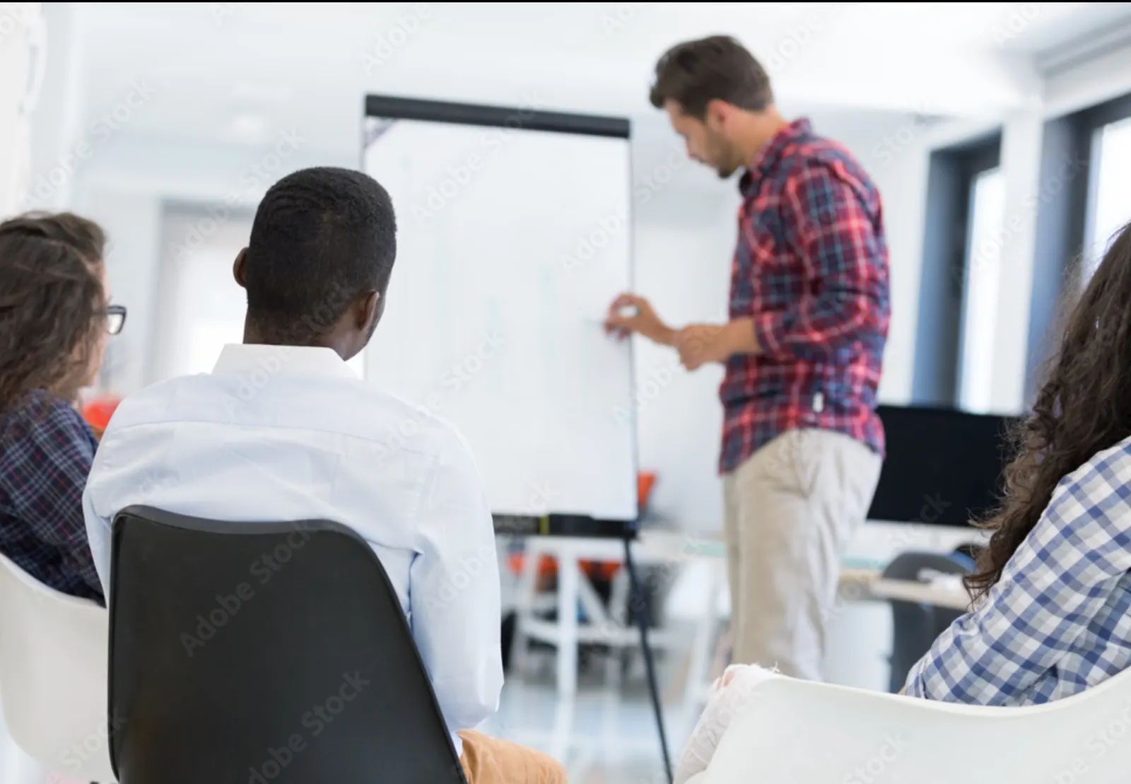 Kleine Gruppe in einer Schulung vor einem Flipchart